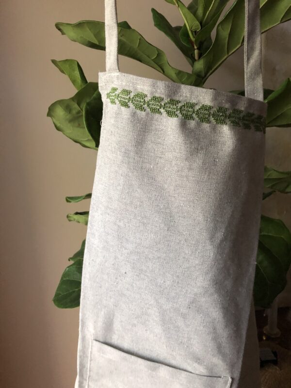 Apron stitched with green olive leaf motif.