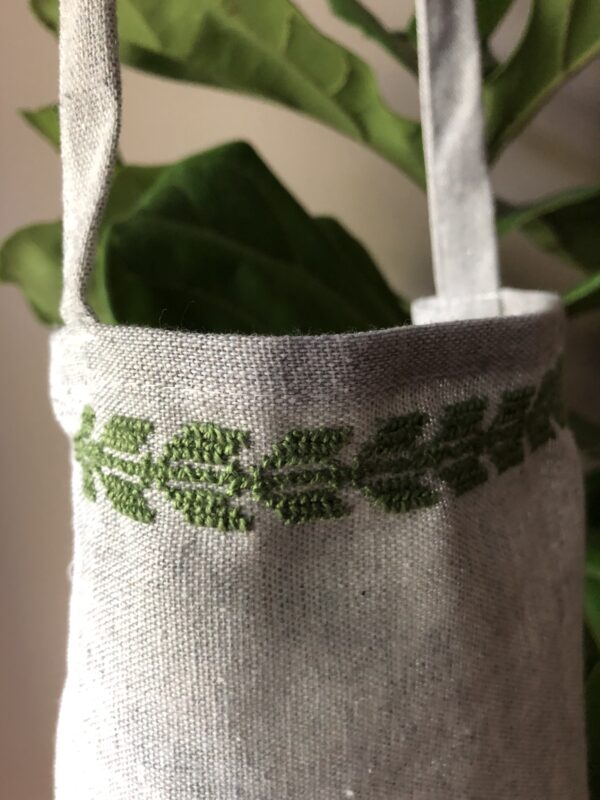 Apron stitched with green olive leaf motif.