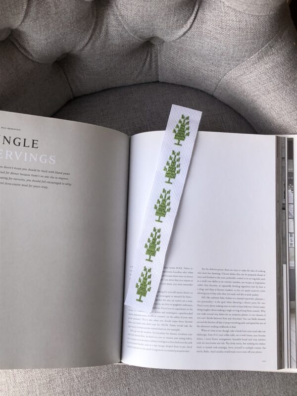 Bookmark stitched with green trees of life.