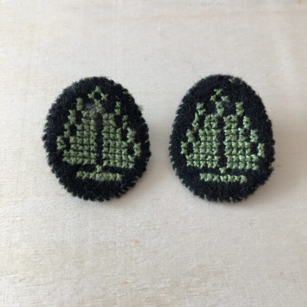 Earrings stitched with a green tree of life motif.